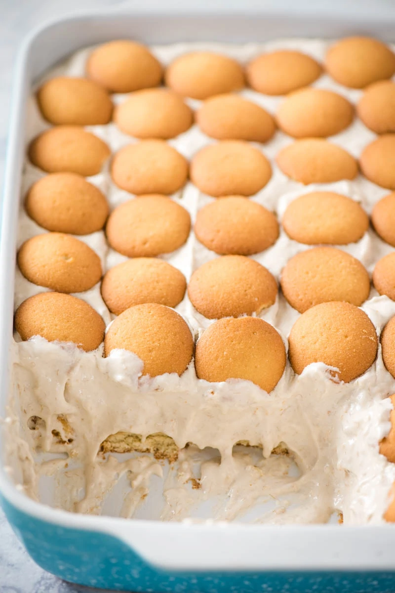 easy banana pudding layered with vanilla wafers in blue baking dish