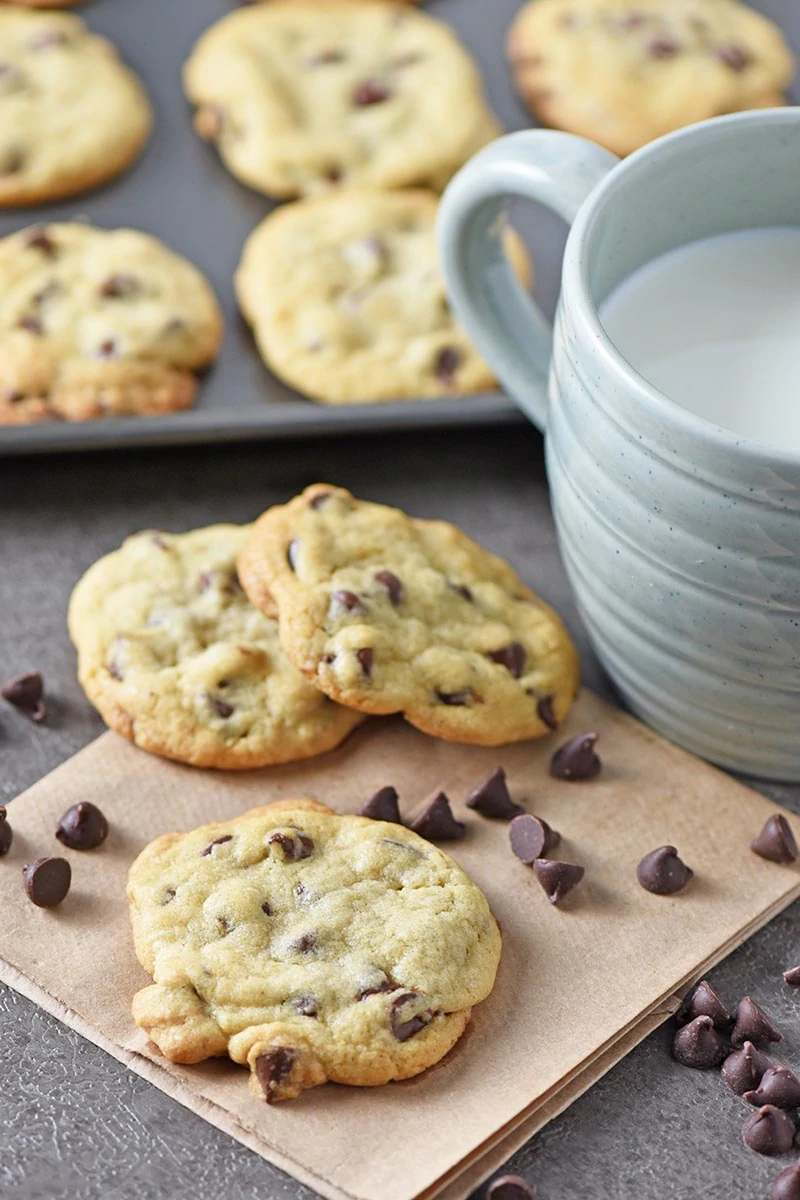 chewy chocolate chip cookies and milk on gray countertop