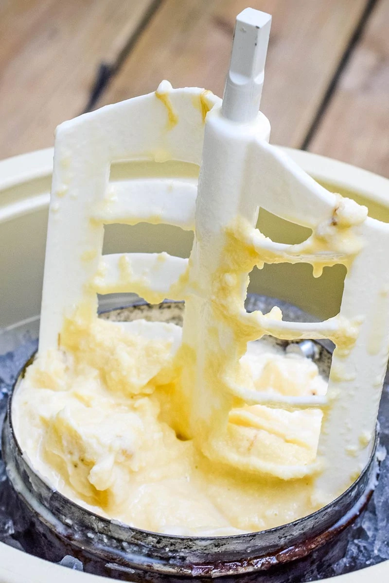 removing churning paddle from homemade banana ice cream in ice cream maker