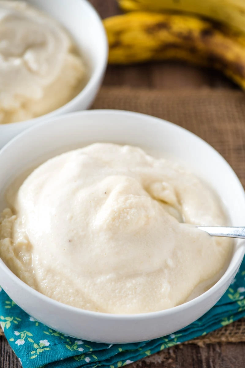 white bowl of soft serve banana ice cream with spoon