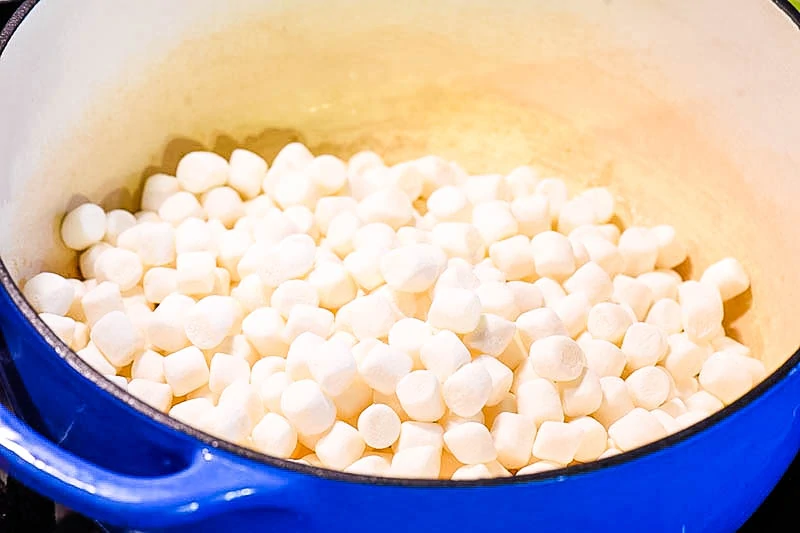 mini marshmallows for Rice Krispie treats recipe in blue Dutch oven