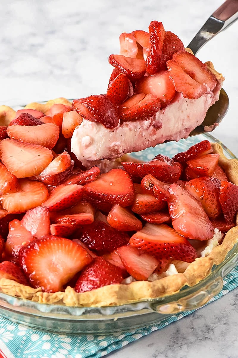 slicing no bake strawberry cream pie with pie server