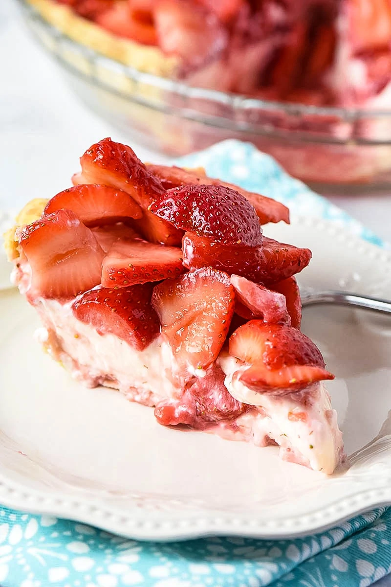 slice of strawberry pie on white plate with fork