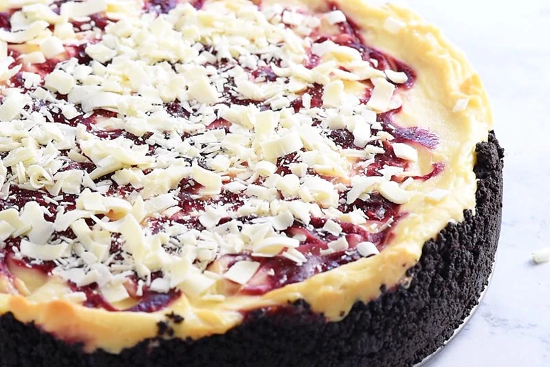 shredded white chocolate on top of raspberry swirl cheesecake