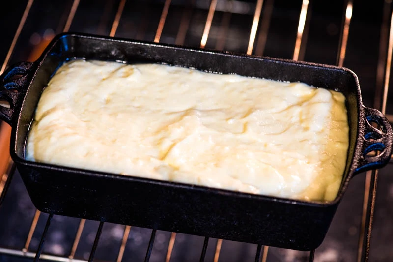 pound cake batter in cast iron loaf pan in oven
