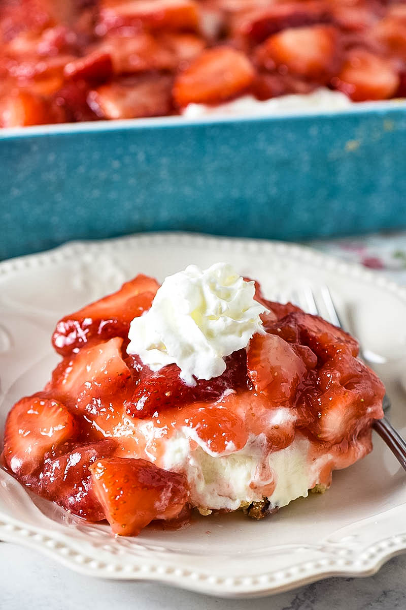 slice of no bake strawberry dessert on white plate with fork