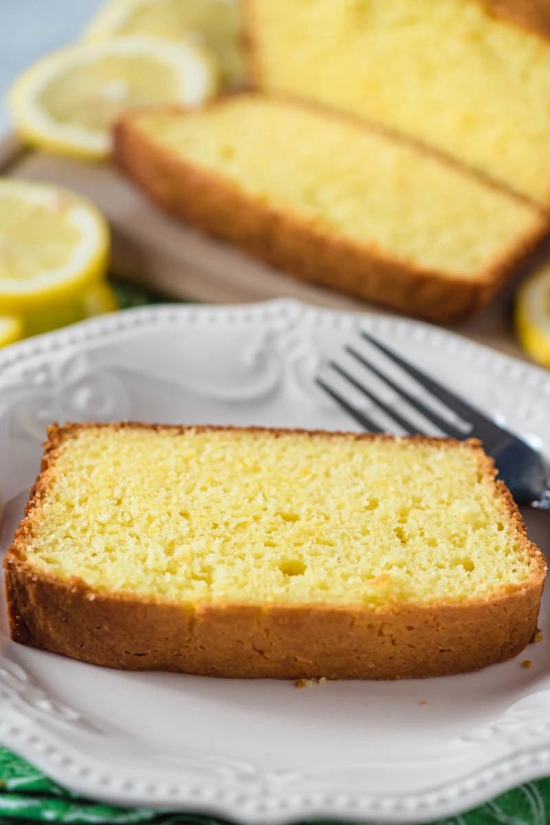 plain slice of moist lemon pound cake on white plate with fork