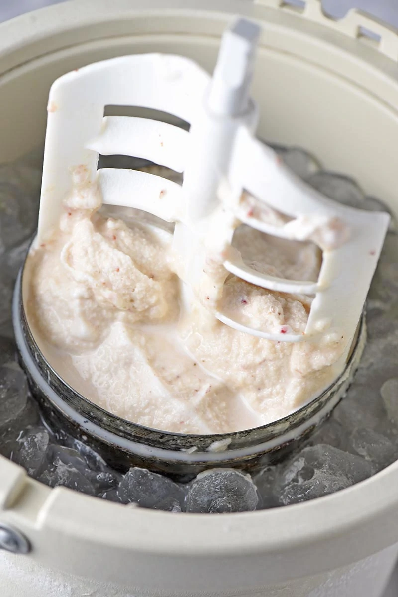 homemade strawberry ice cream in canister with churning paddle