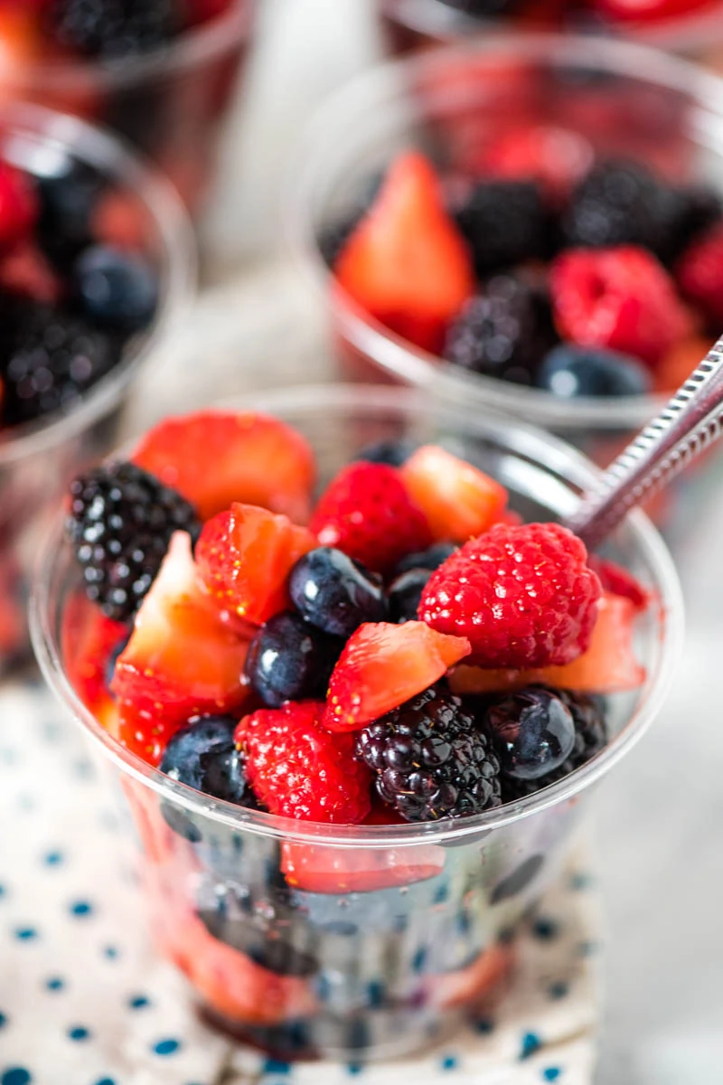 fruit salad cups made with mixed berries in plastic cup with spoon