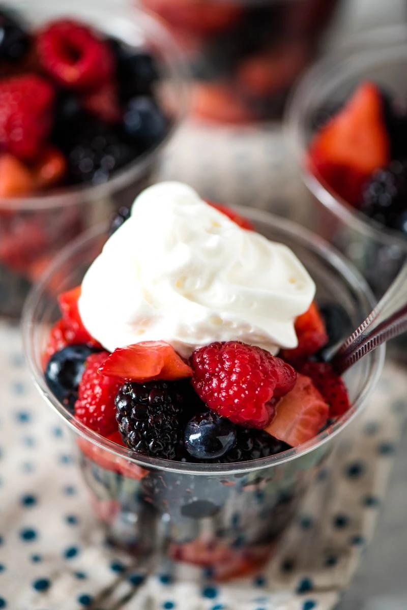 homemade fruit cups with mixed berries and whipped cream on top