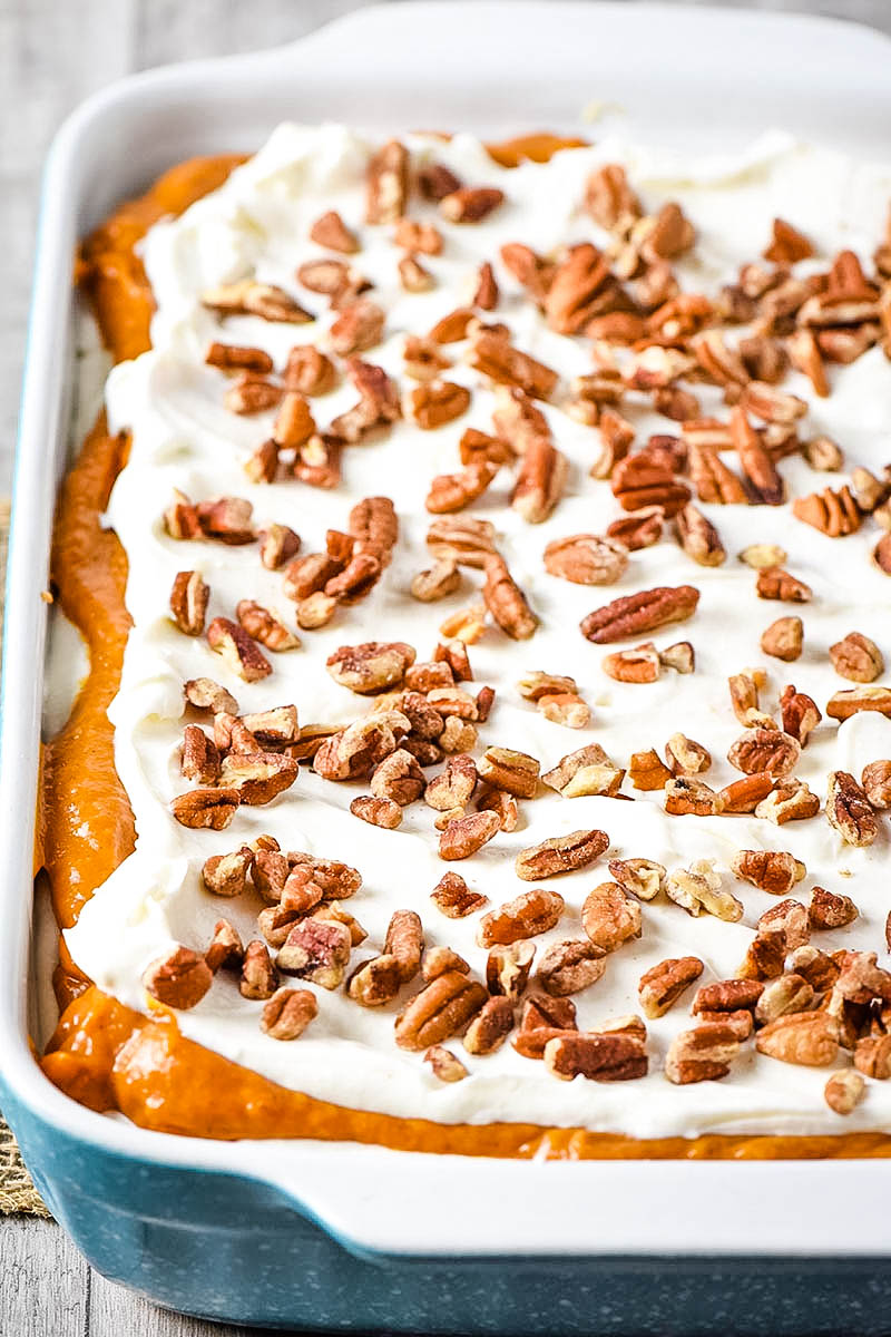 pumpkin delight in blue baking dish with chopped pecans sprinkled on top