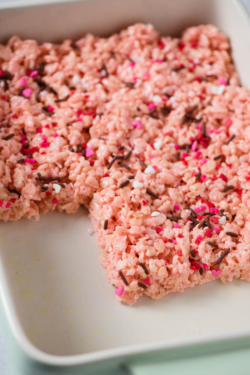 pink Valentine Rice Krispie treats with sprinkles in mint green baking dish