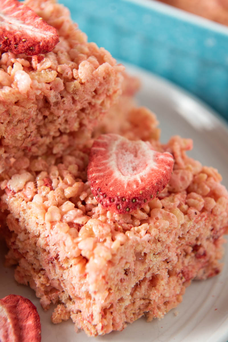 stack of strawberry Rice Krispie treats with freeze-dried strawberries on white plate