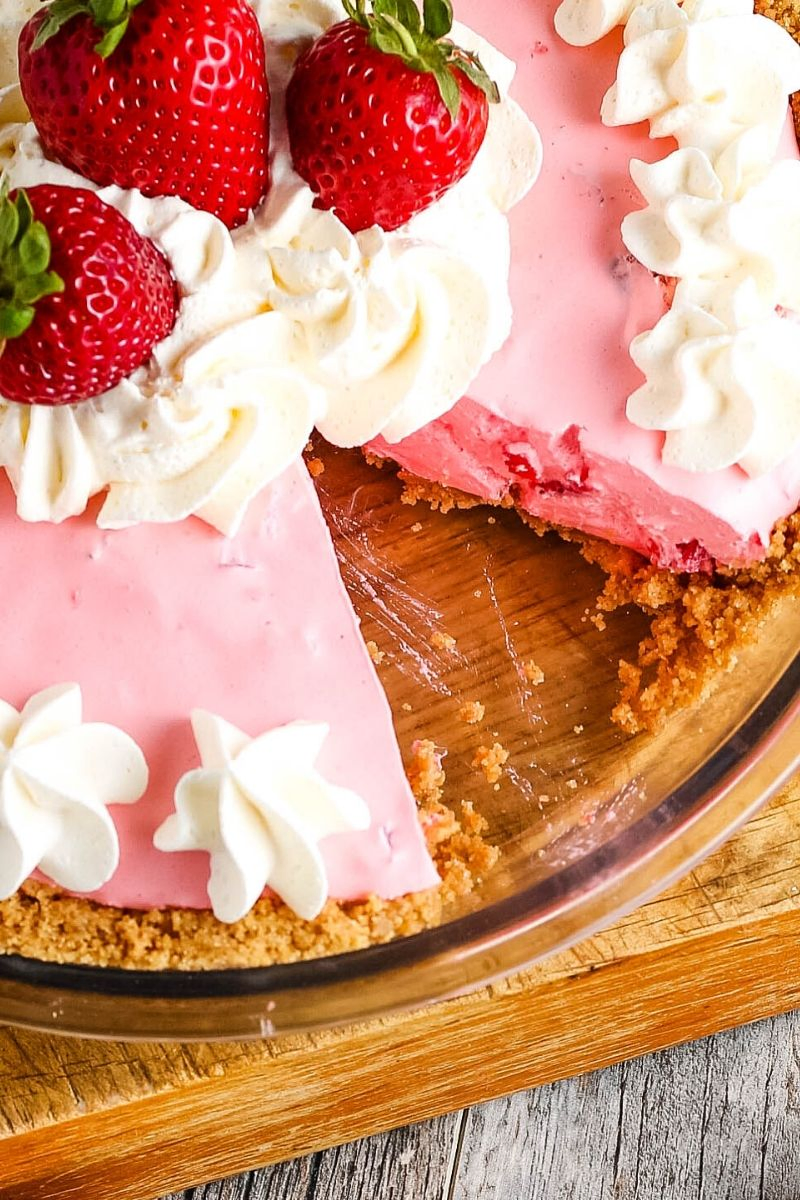 sliced strawberry Jello pie in pie plate, decorated with whipped cream and fresh strawberries