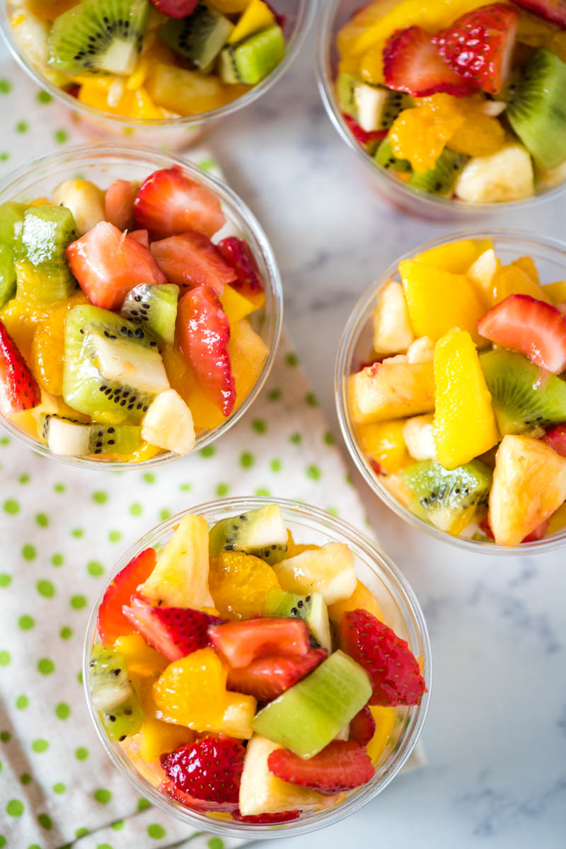 mini tropical fruit salads filled with fresh strawberries, kiwi, bananas, pineapple, and mandarin oranges