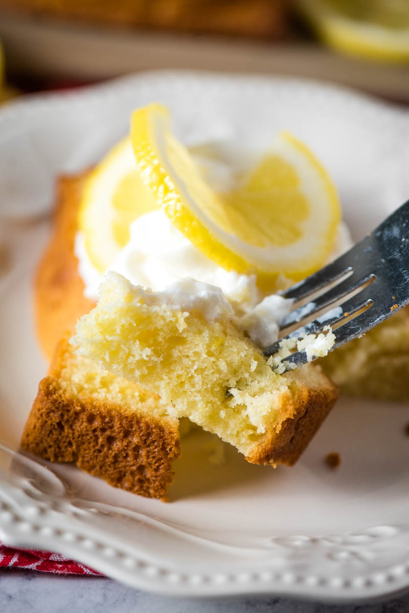 bite of gluten-free lemon pound cake on fork over white plate