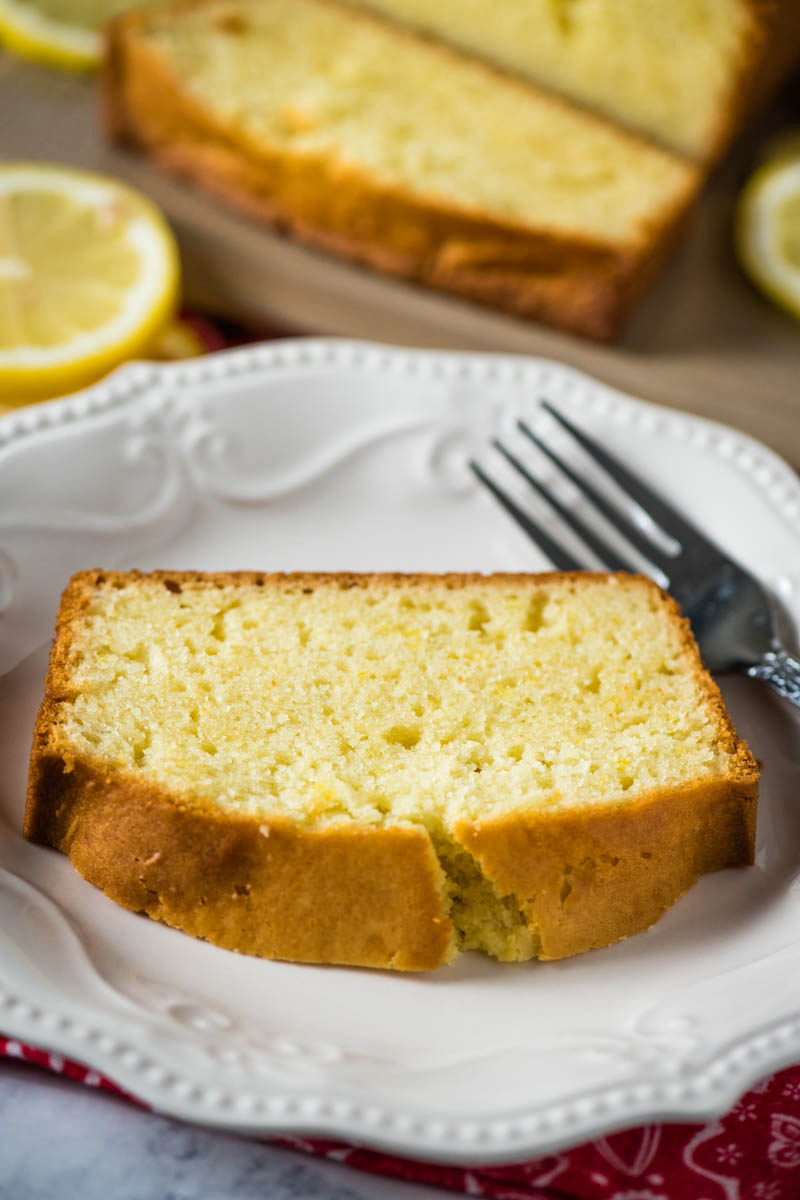 slice of gluten-free lemon loaf cake on white plate with fork