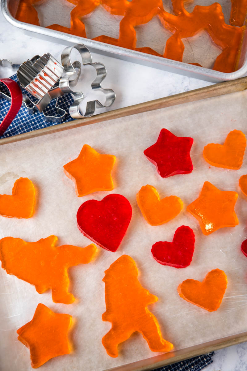 orange and cherry Jello Jigglers in heart, star, and Bigfoot shapes on baking sheet