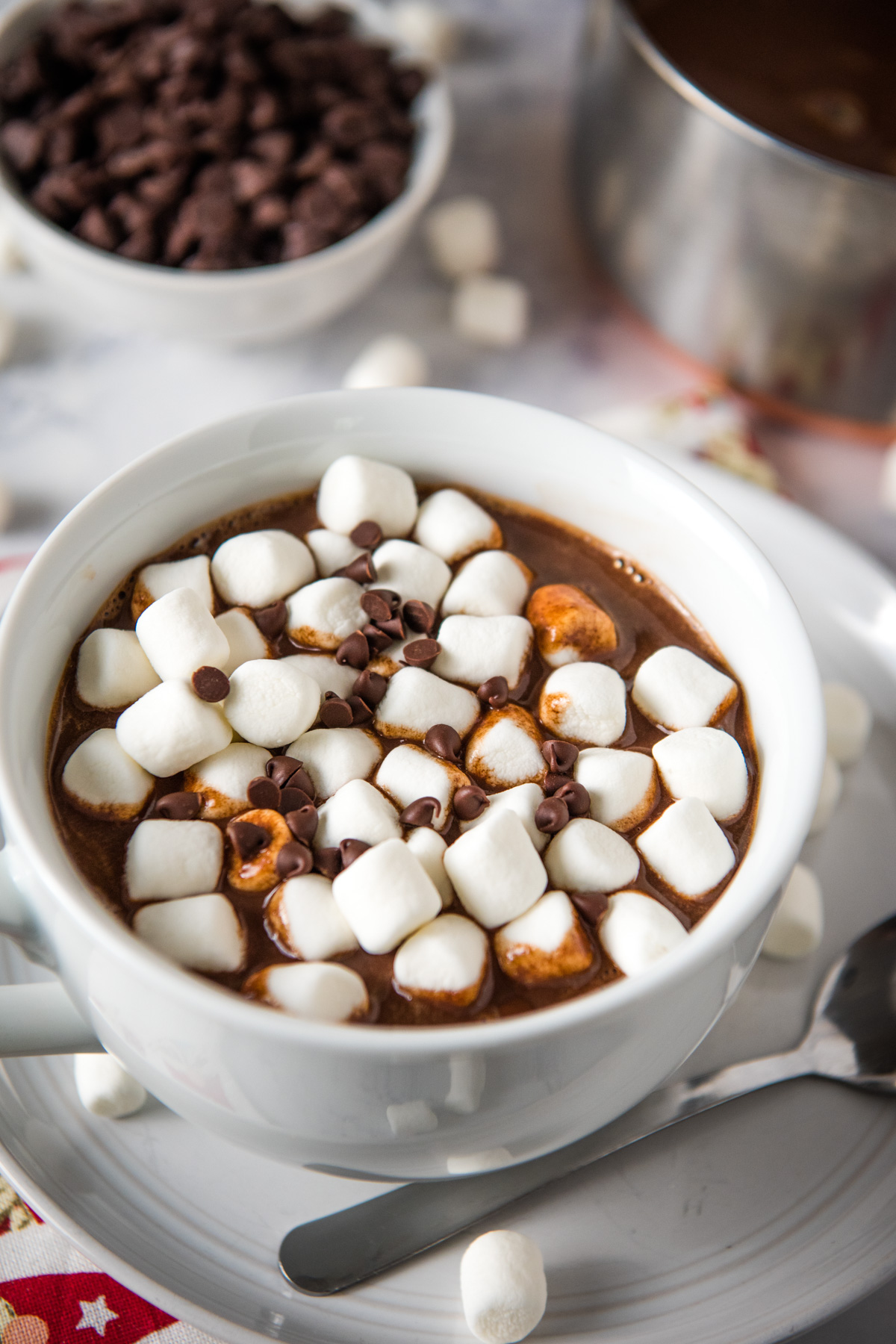 white mug of hot chocolate with chocolate chips and mini marshmallows