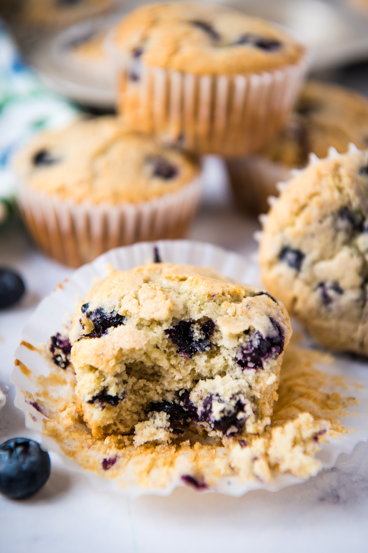 gluten-free blueberry muffin split in half on white cupcake liner