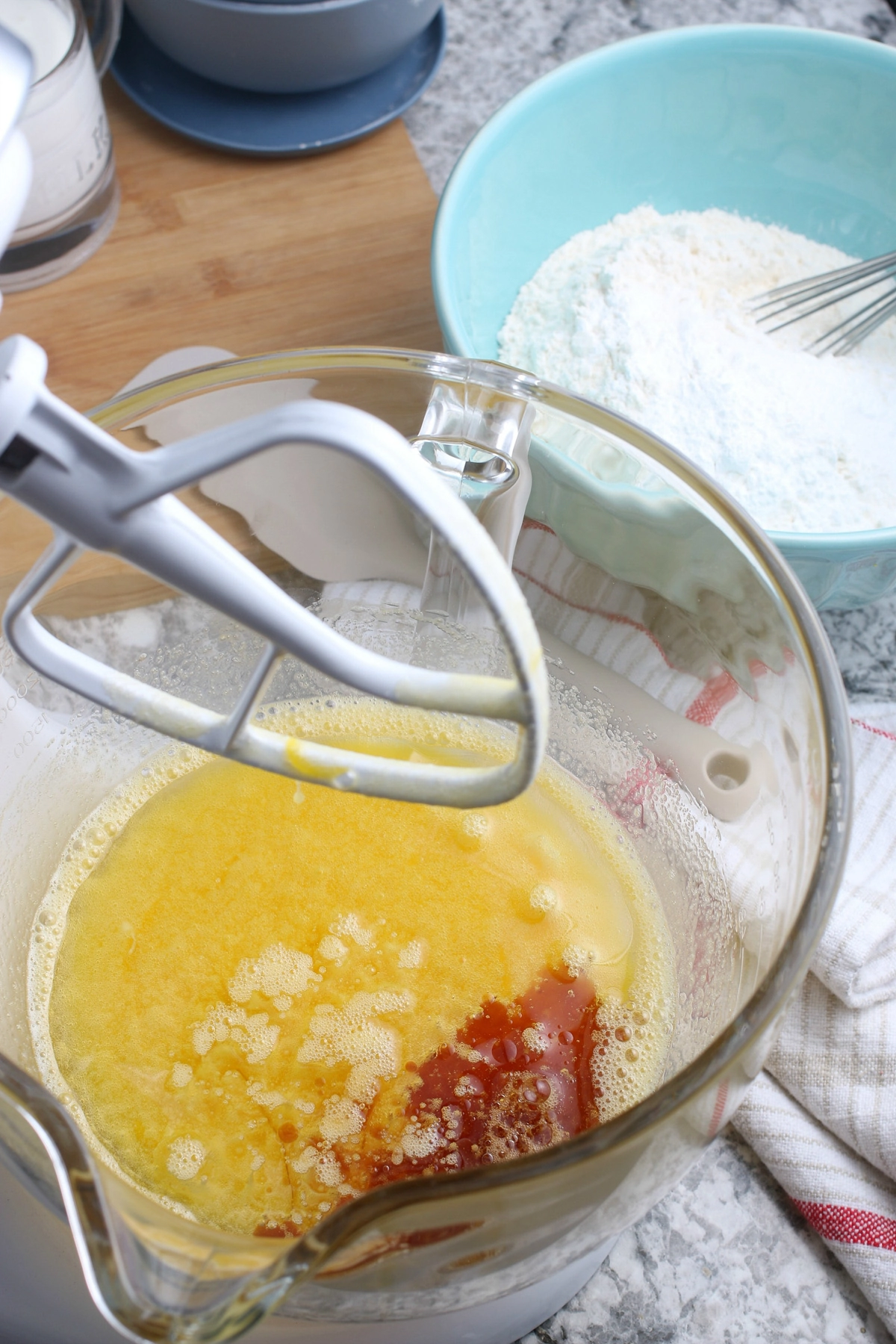mixing eggs with canola oil and vanilla extract in glass bowl on stand mixer