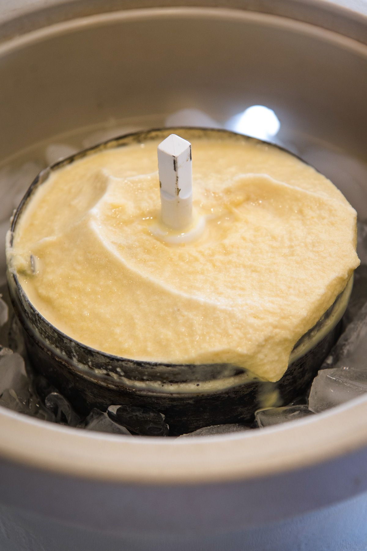frozen banana ice cream in metal canister of old ice cream maker