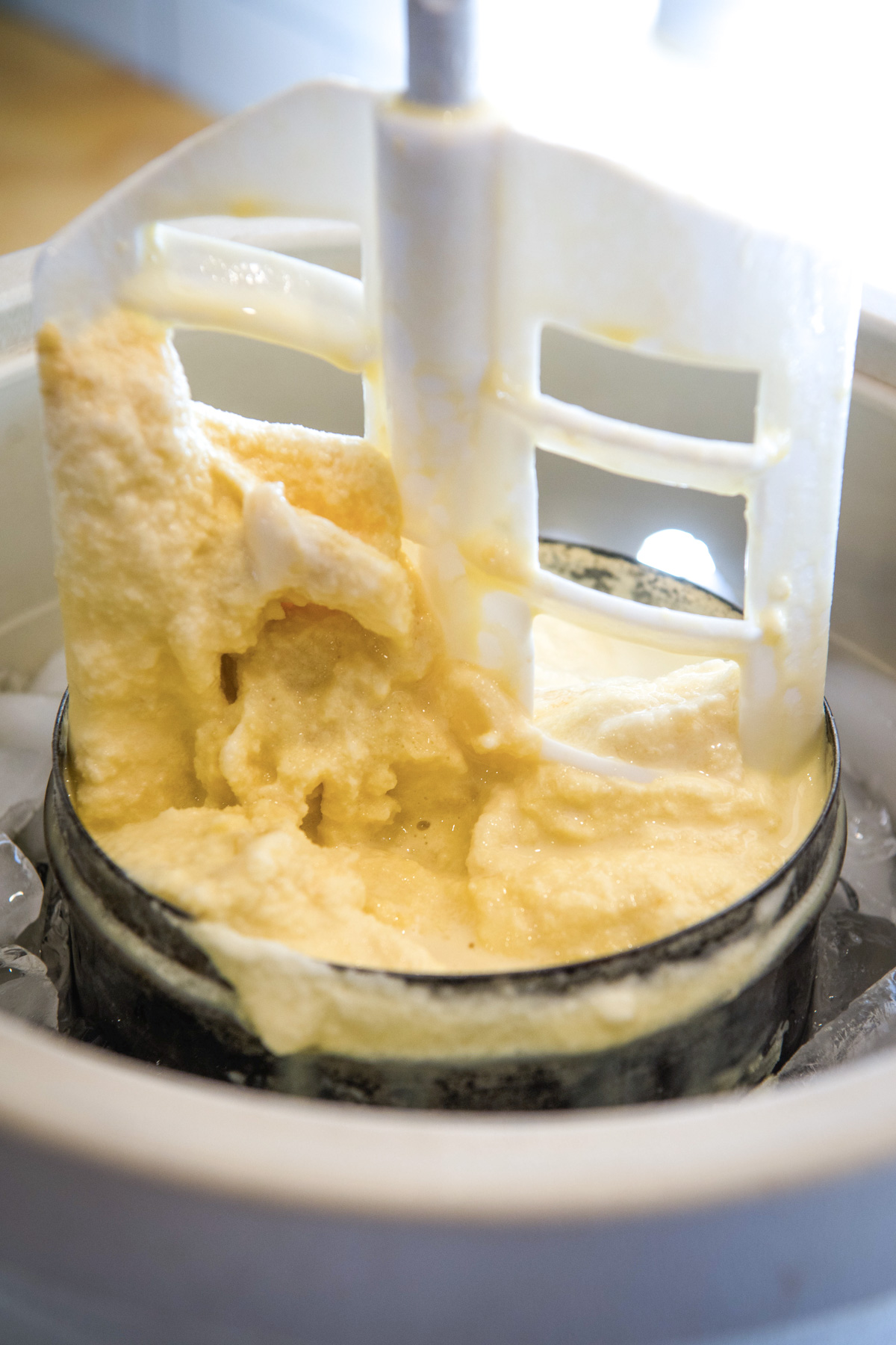 old-fashioned ice cream maker with churn paddle covered in homemade banana ice cream