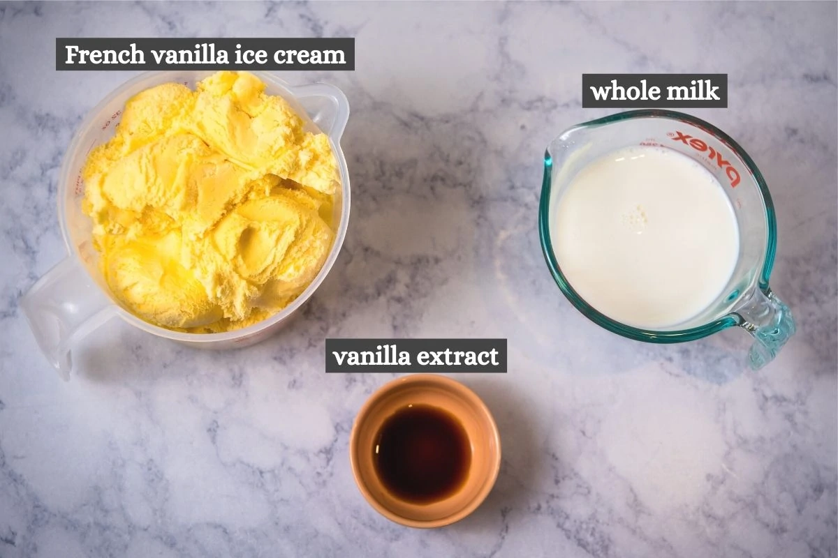 real vanilla milkshake ingredients on white marble countertop