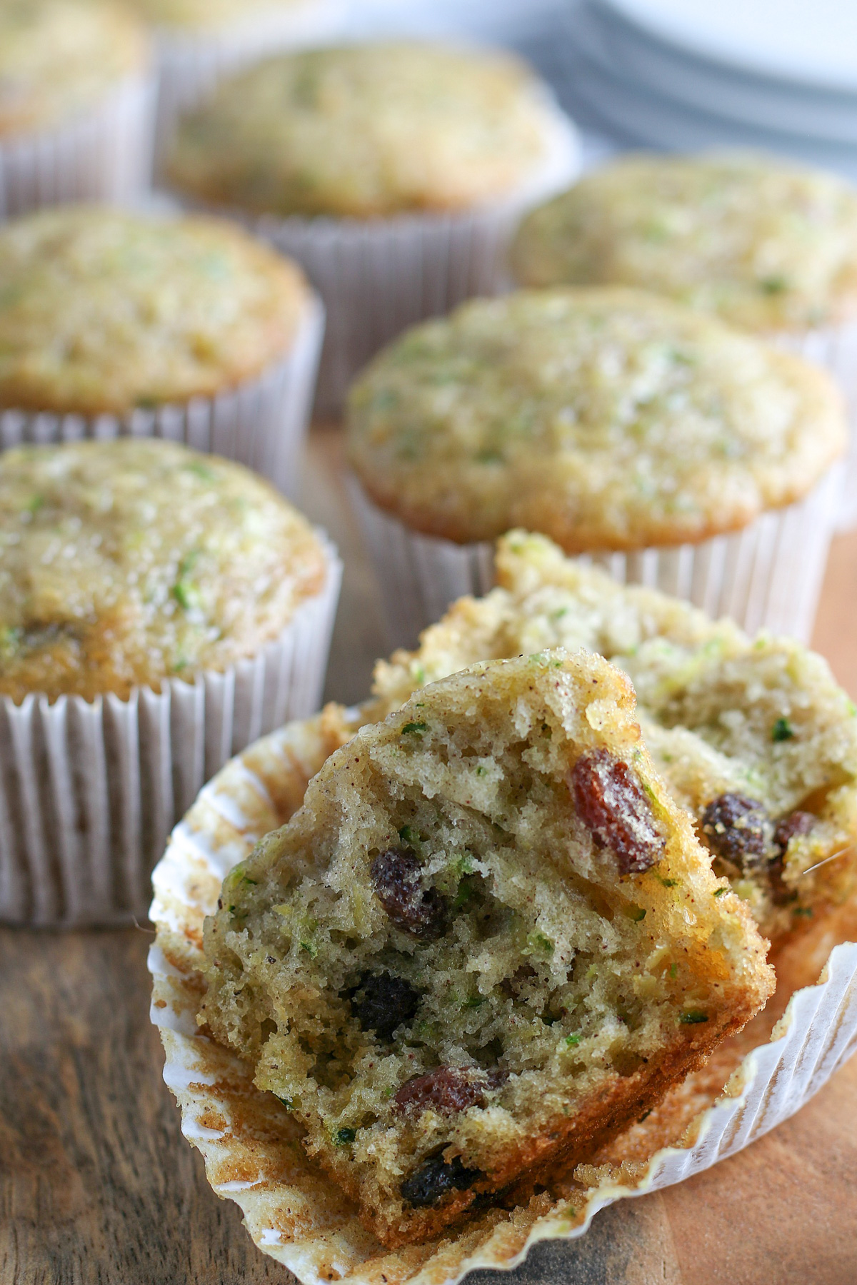 dairy-free zucchini muffins on wooden cutting board with one muffin cut in half