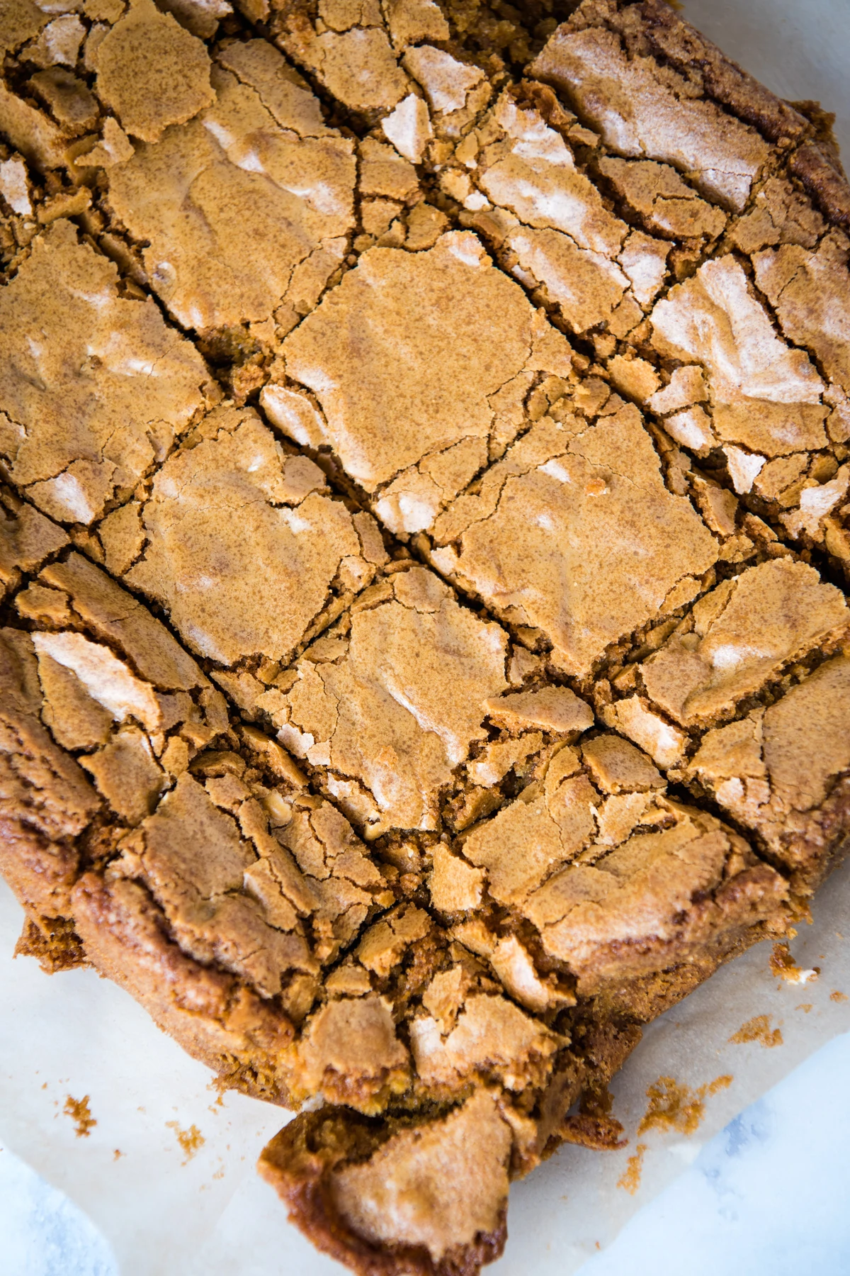 sliced dairy-free blondies on parchment paper on white marble countertop