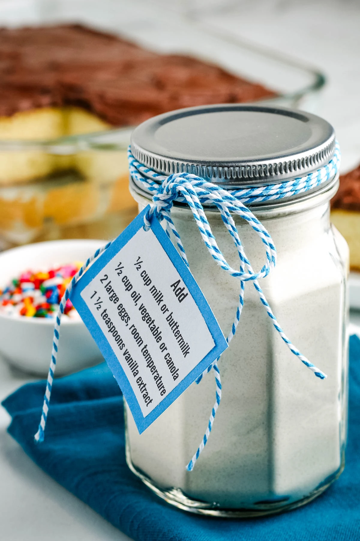 homemade cake mix in a small glass jar on a dark blue tea towel