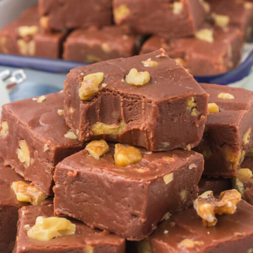 fantasy fudge stacked up with a bite taken out on a decorative plate