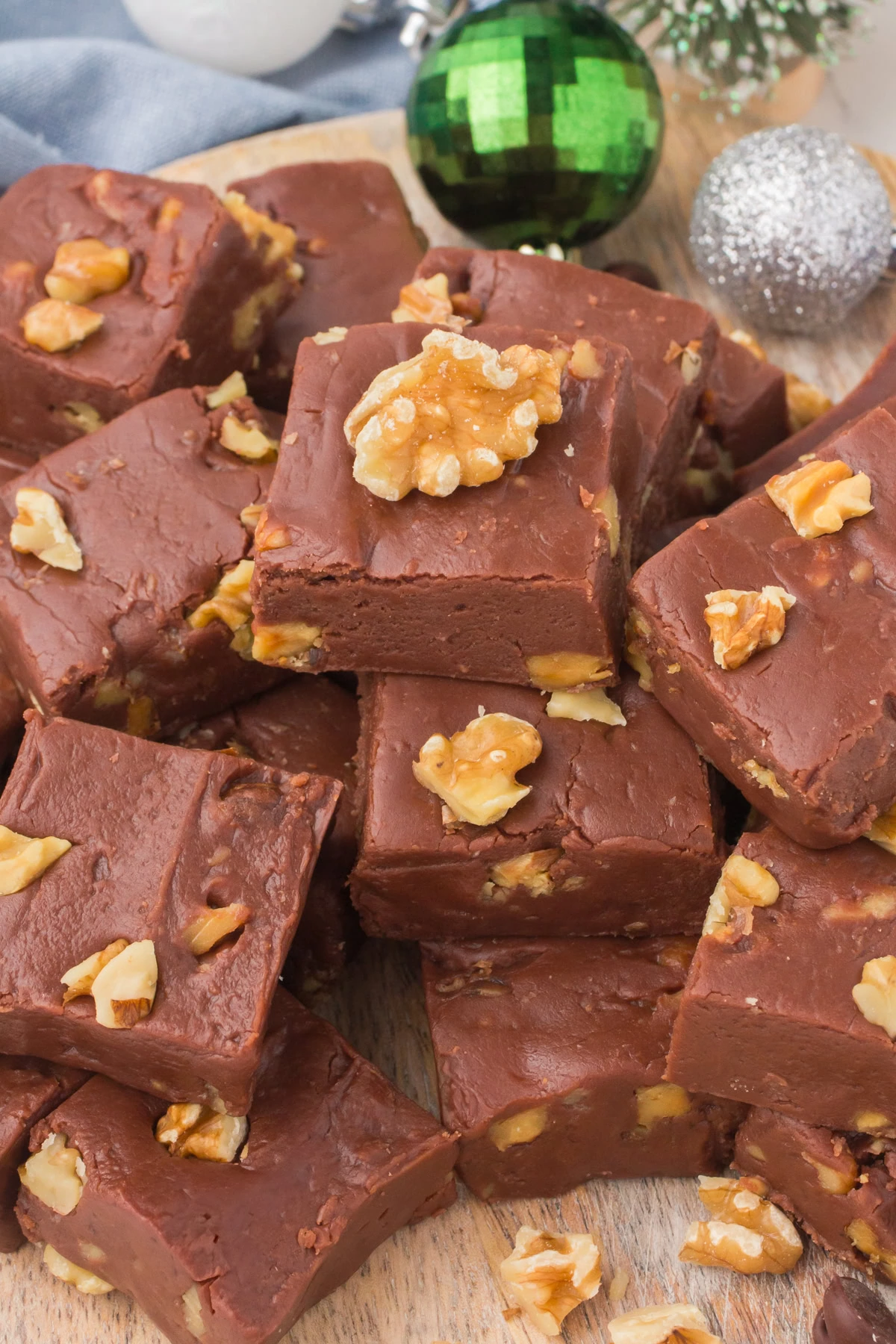 original fantasy fudge with walnuts and chocolate chips stacked up on unbleached parchment paper