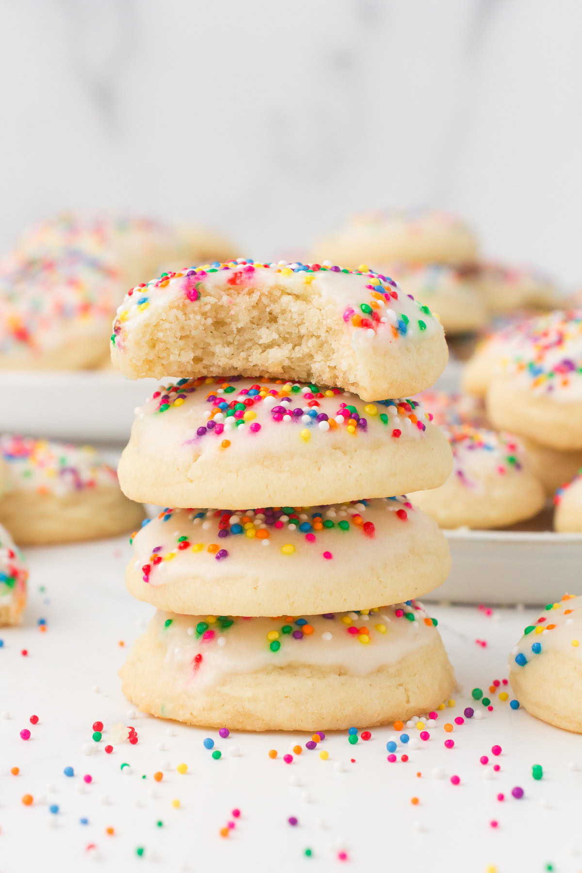 Italian sprinkle cookies stacked up with a bite taken out
