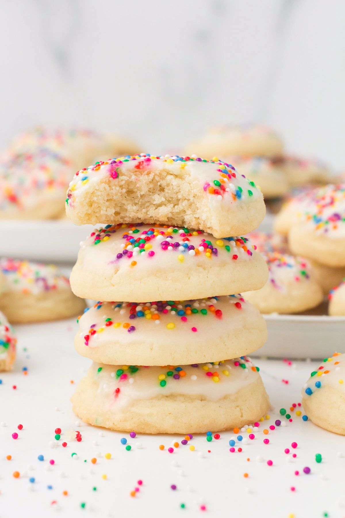 Italian sprinkle cookies stacked up with a bite taken out